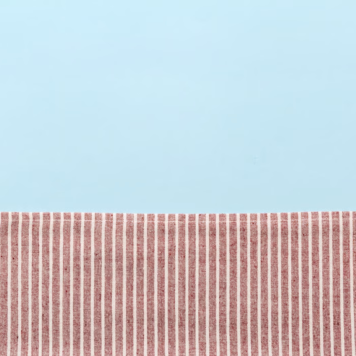 top view with red empty kitchen napkin isolated on table background. Folded cloth